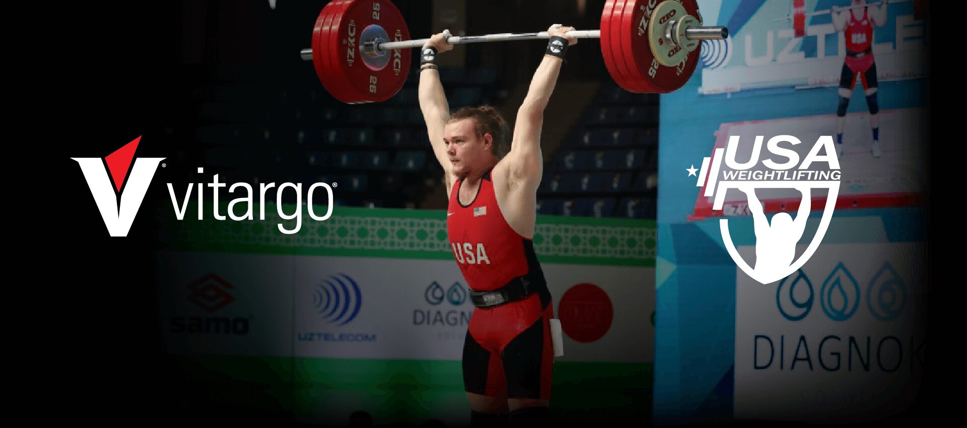 A man in red and black lifting a barbell.