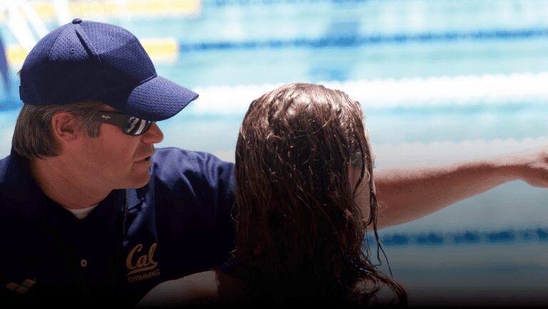 A person in a swimming pool talking to someone.