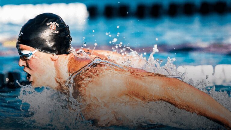 A person swimming in the water with a helmet on.