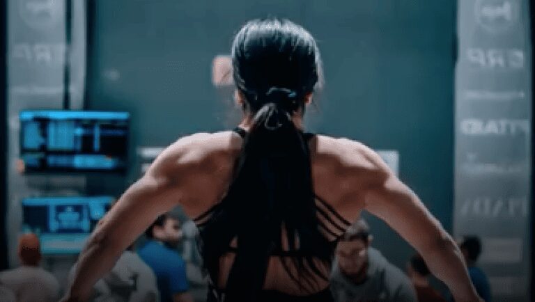 A woman with long hair is standing in front of other people.